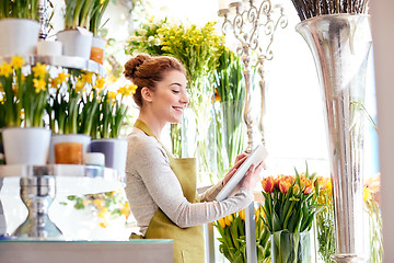 Image showing woman with tablet pc computer at flower shop