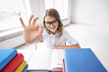 Image showing happy school girl with books showing ok sign