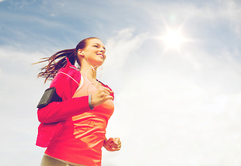 Image showing smiling young woman running outdoors