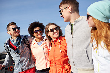 Image showing smiling friends in sunglasses laughing on street