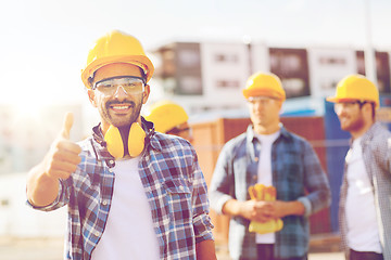 Image showing group of smiling builders in hardhats outdoors