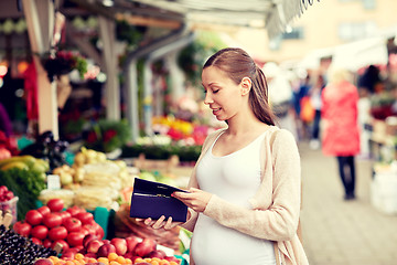 Image showing pregnant woman with wallet buying food at market