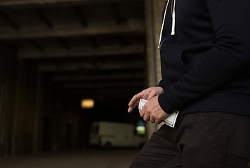 Image showing close up of addict or drug dealer hands with money