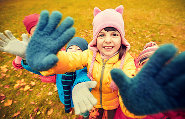 Image showing happy children waving hands in autumn park