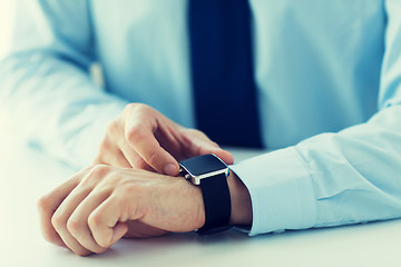 Image showing close up of male hands setting smart watch