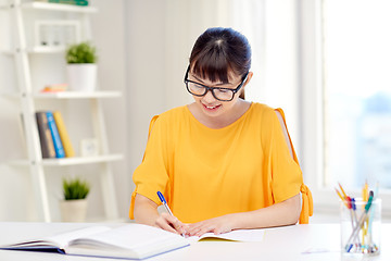 Image showing happy asian young woman student learning at home