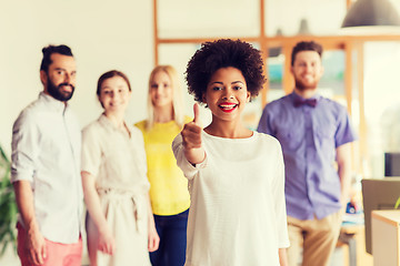 Image showing woman showing thumbs up over creative office team