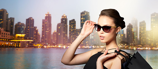 Image showing happy woman in black sunglasses with shopping bags