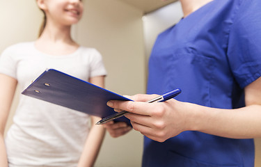 Image showing close up of nurse with clipboard and pen with girl