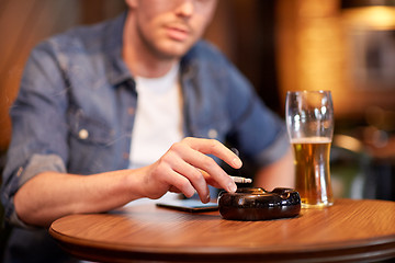 Image showing man drinking beer and smoking cigarette at bar