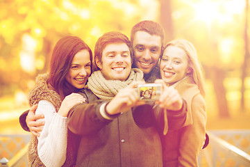 Image showing group of friends with photo camera in autumn park