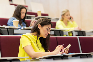 Image showing student girls with smartphones on lecture