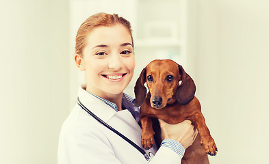 Image showing happy doctor with dog at vet clinic