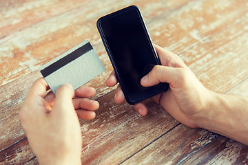 Image showing close up of hands with smart phone and credit card