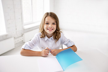 Image showing happy smiling school girl with notebook and pen