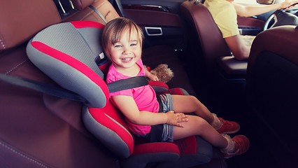 Image showing happy child sitting in car seat and father driving