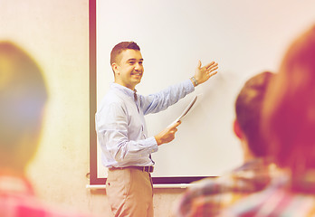 Image showing group of students and smiling teacher with notepad