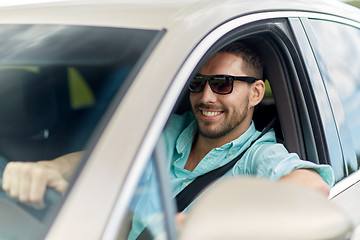 Image showing happy smiling man in sunglasses driving car