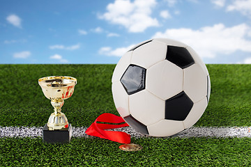 Image showing close up of football ball, golden cup and medal