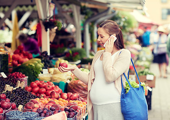 Image showing pregnant woman calling on smartphone at market