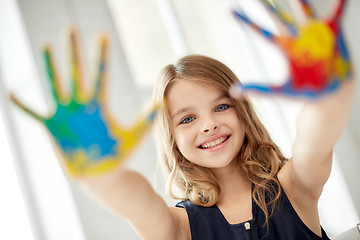 Image showing happy girl showing painted hand palms at home