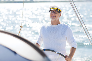 Image showing senior man at helm on boat or yacht sailing in sea