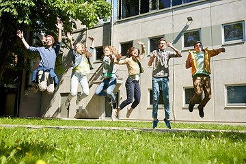 Image showing happy teenage students or friends jumping outdoors