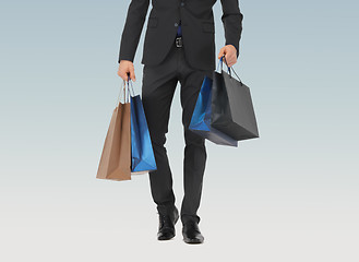 Image showing close up of man in suit with shopping bags