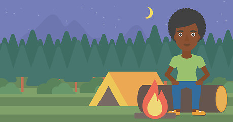 Image showing Woman sitting on log in the camping.