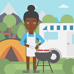 Image showing Woman having barbecue in front of camper van.