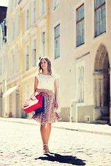 Image showing happy woman with shopping bags walking in city