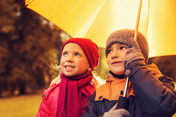 Image showing happy boy and girl with umbrella in autumn park