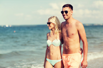 Image showing happy couple in swimwear walking on summer beach