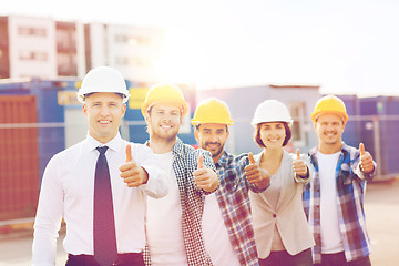 Image showing group of smiling builders in hardhats outdoors