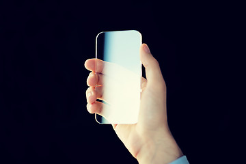 Image showing close up of male hand with transparent smartphone