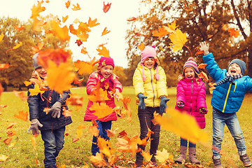 Image showing happy children playing with autumn leaves in park