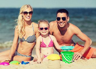 Image showing happy family playing with sand toys on beach