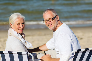 Image showing senior couple sitting on chairs at summer beach