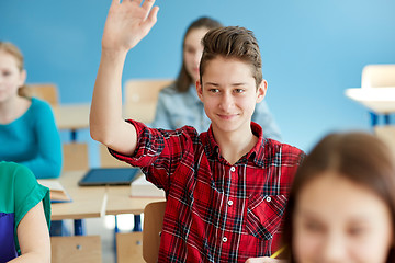 Image showing happy student boy raising hand at school lesson