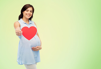 Image showing happy pregnant woman with red heart touching belly