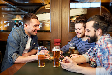 Image showing men with smartphones drinking beer at bar or pub