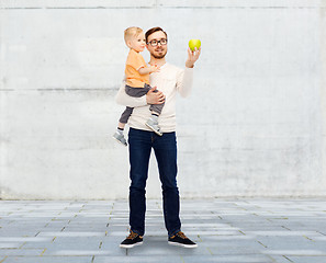 Image showing happy father and little son with green apple