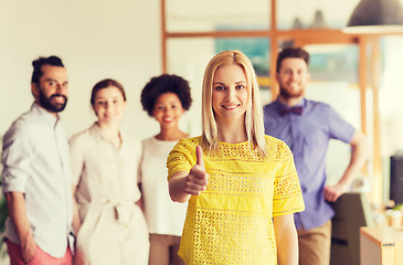 Image showing woman showing thumbs up over creative office team