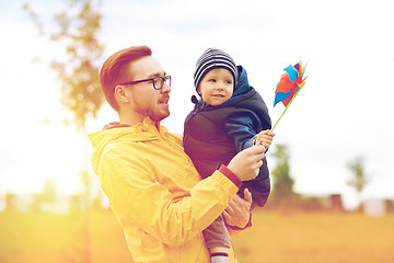 Image showing happy father and son with pinwheel toy outdoors