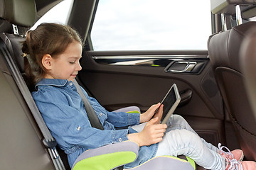 Image showing happy little girl with tablet pc driving in car