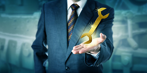Image showing Male Professional Is Presenting A Golden Wrench