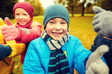 Image showing happy children showing thumbs up in autumn park