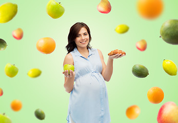 Image showing happy pregnant woman with apple and croissant