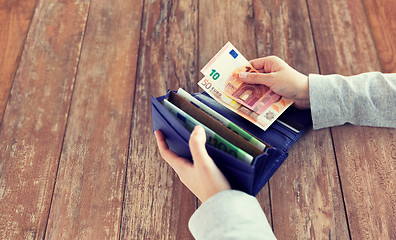 Image showing close up of woman hands with wallet and euro money