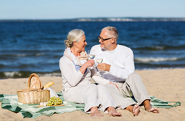 Image showing happy senior couple having picnic on summer beach